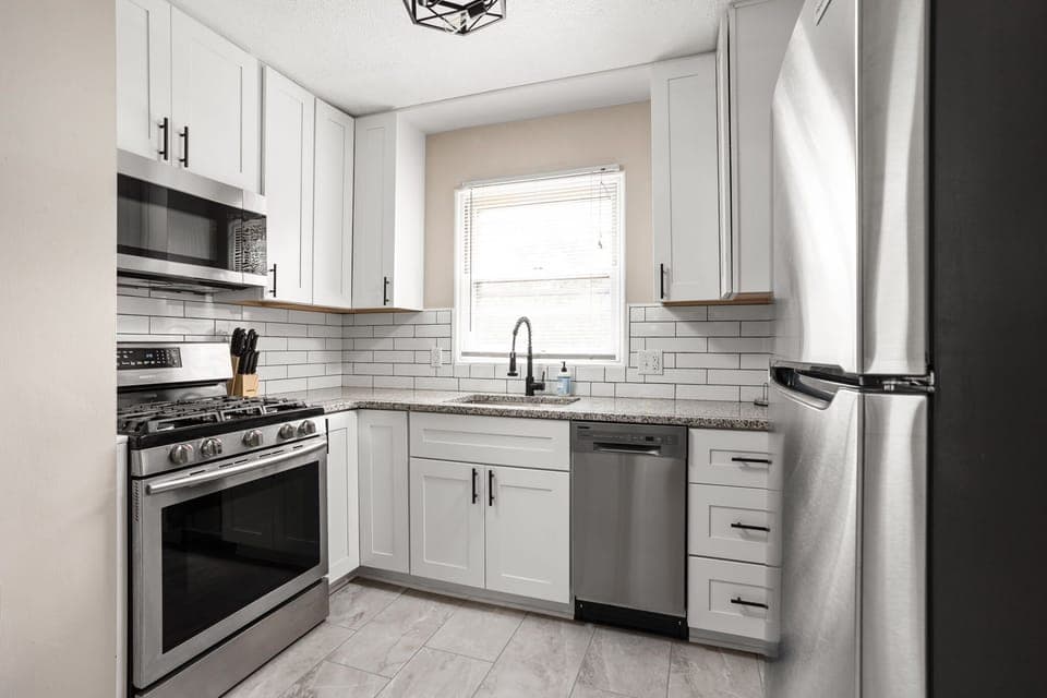 Modern kitchen with stainless steel appliances, subway tile backsplash and all of the necessities for your stay!