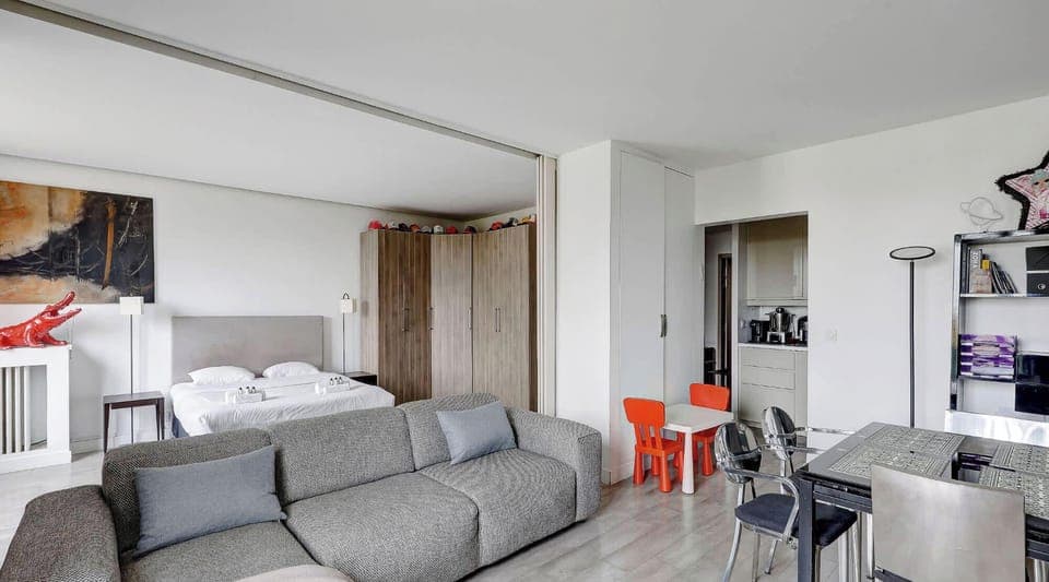 Espace ouvert et lumineux avec coin nuit séparé par une cloison coulissante, grand canapé, coin repas.