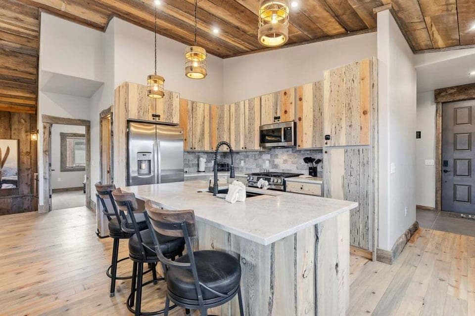 Gather around this gorgeous kitchen island where rustic wood beams and modern appliances create the perfect cooking sanctuary for your mountain retreat at 128 GCR 4034.