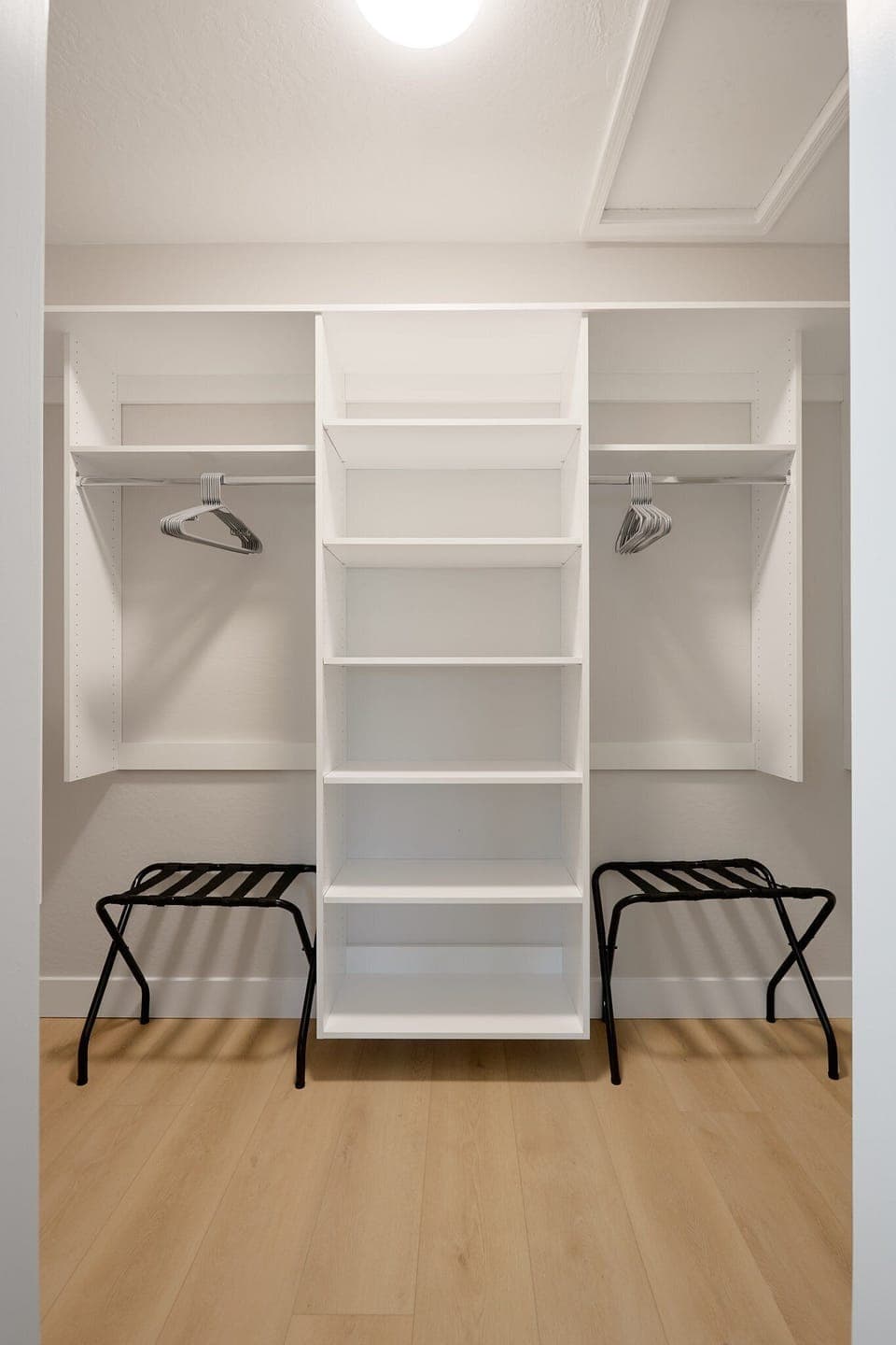 Inviting primary bedroom with a King bed, cozy seating, walk-in closet, en-suite bathroom, and private balcony, creating a serene retreat with warm, natural tones.