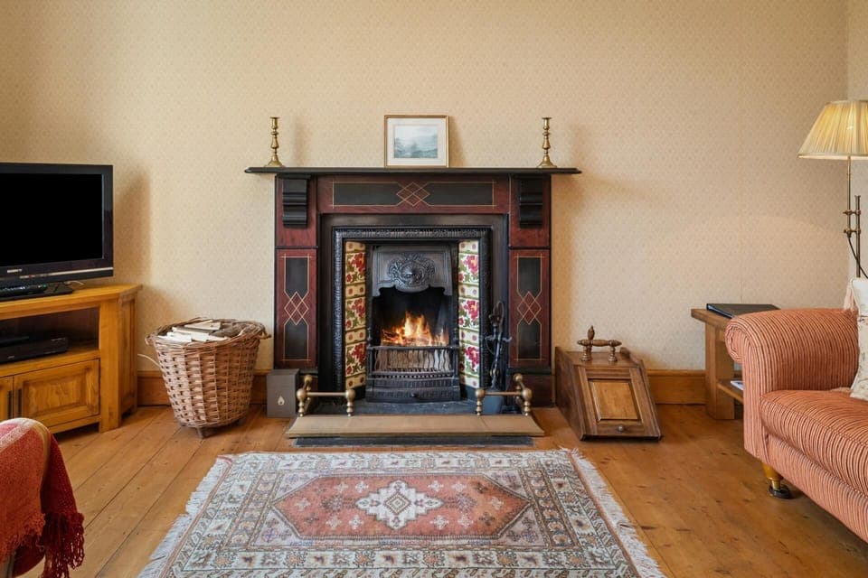 Traditional open fire place with a basket of logs and coal skuttle