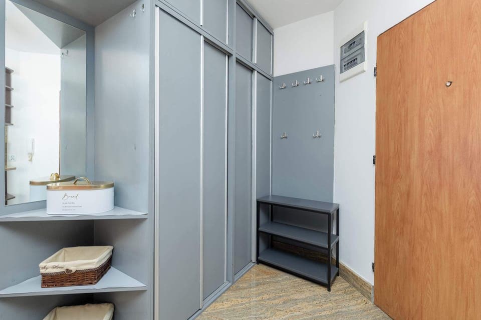 A hallway with built-in wardrobes and mirrors. The clean lines and neutral tones make it both functional and visually appealing.