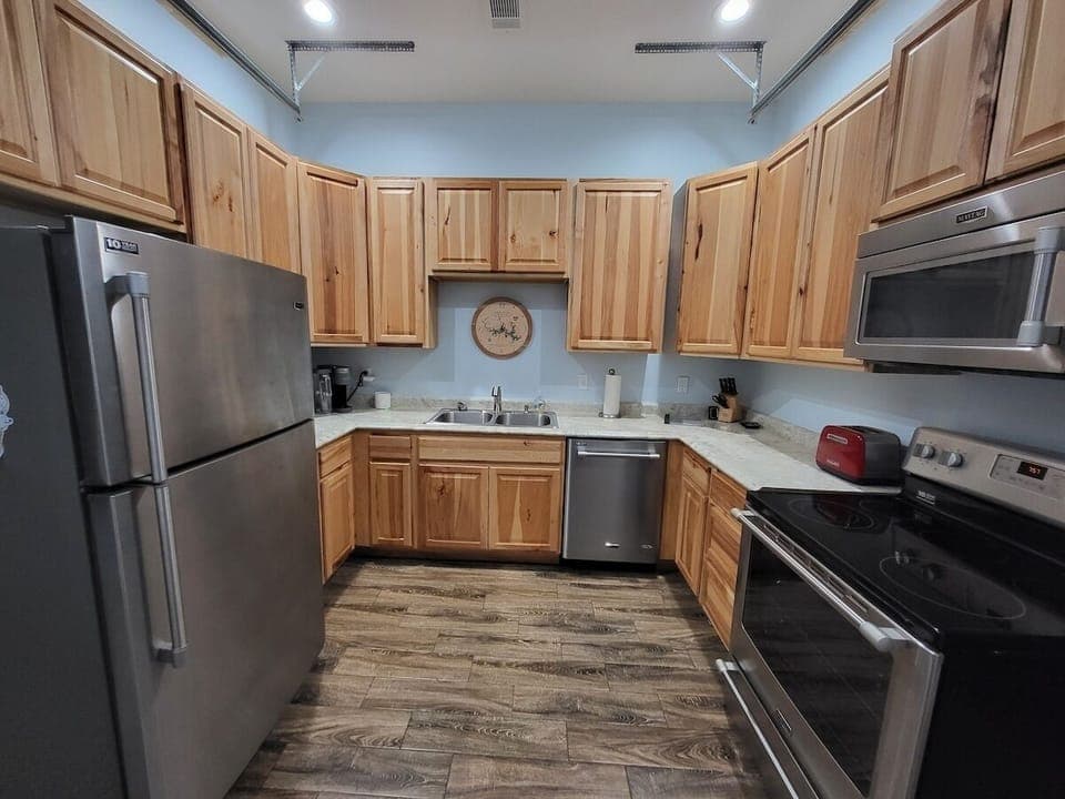 Fully equipped kitchen with stainless appliances, wood cabinets, and essentials.