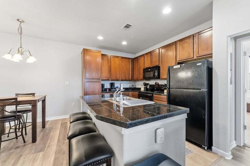 Your spacious kitchen features granite counters, modern appliances, and a breakfast bar perfect for morning coffee or casual meals.