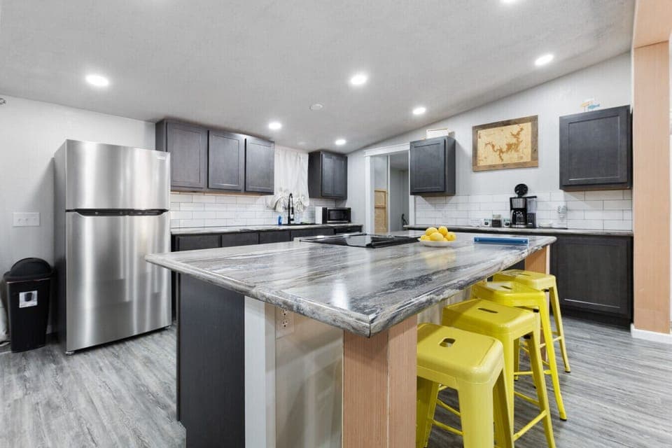 Modern Kitchen | Large Island with Bar Seating | Stainless Steel Appliances | Sleek Gray Cabinets & Subway Tile Backsplash