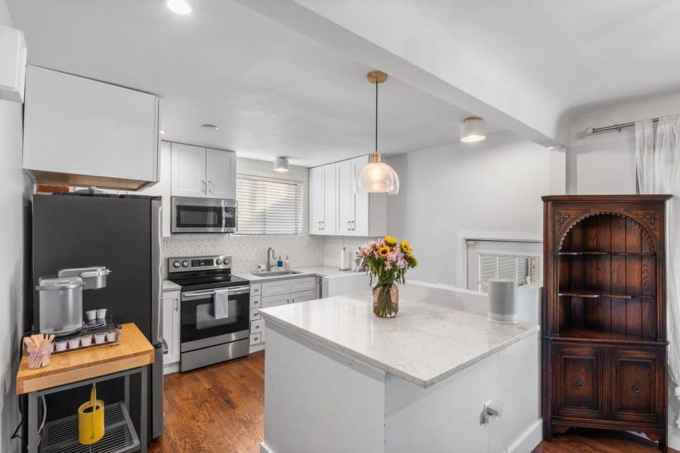 Step into your bright, fully-equipped kitchen where you'll love preparing meals on gleaming countertops. The spacious island becomes your morning coffee spot as warm light filters through windows.
