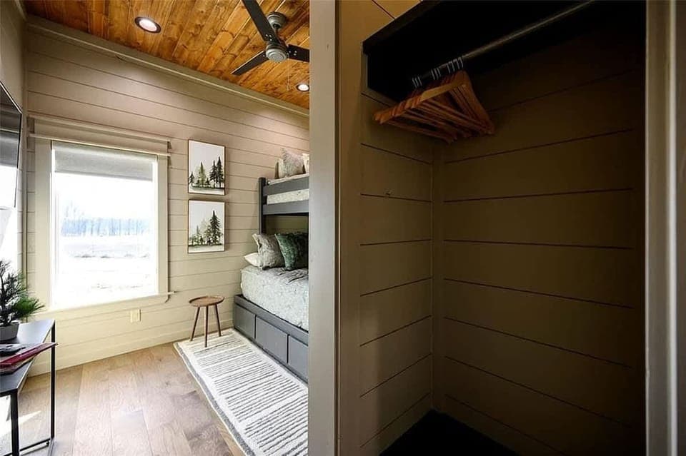 Bright bunk room with built in closet cozy bedding and natural light 