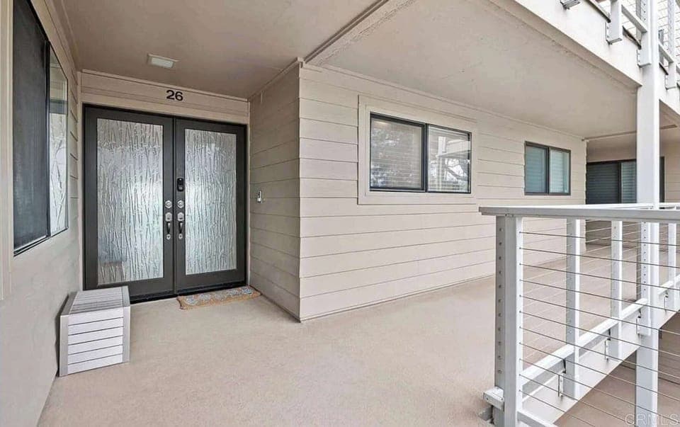 Entry is secure via stylish double doors with coded access. The covered walkway and modern railing offer a clean, inviting approach to your stay.