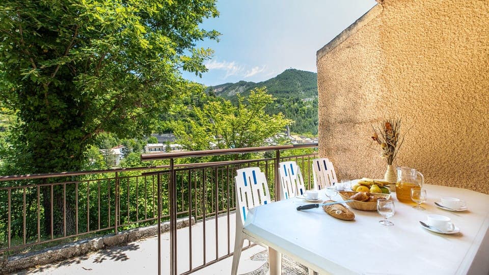 Sunny terrace with outdoor dining and stunning views of the surrounding mountains.