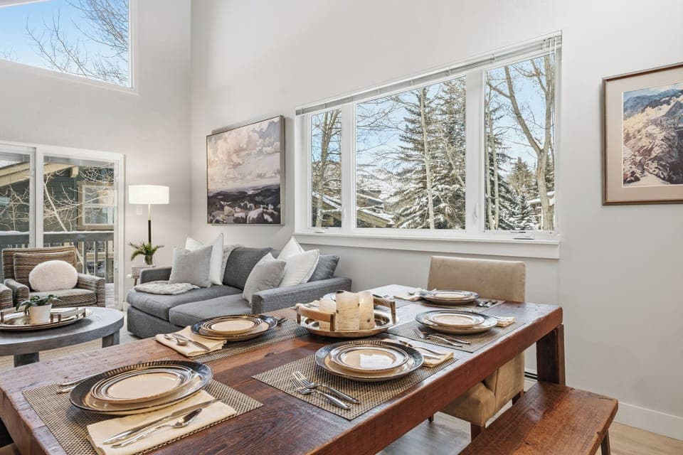 Dining table set for shared meals, framed by natural light and mountain views