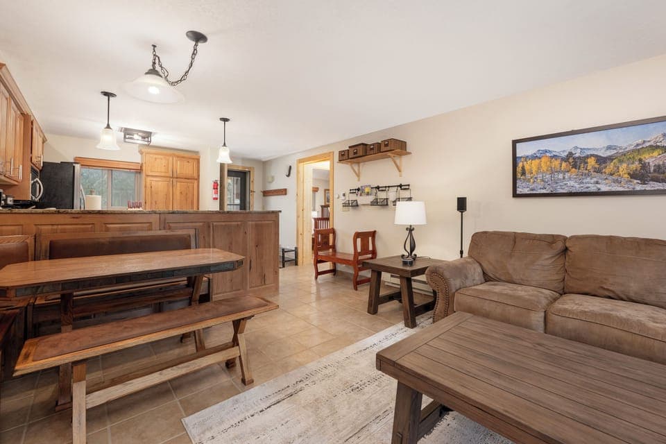 Relax in your spacious living area with rustic wood furnishings and mountain art, perfect for unwinding after your adventures.