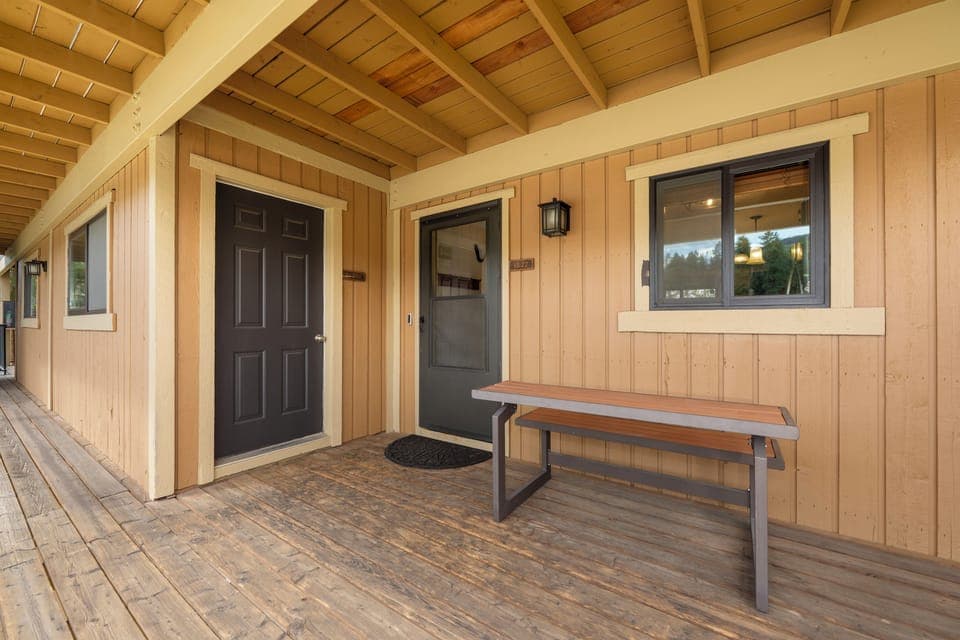 Rustic wood exterior with covered walkway featuring a convenient bench for relaxing between adventures.