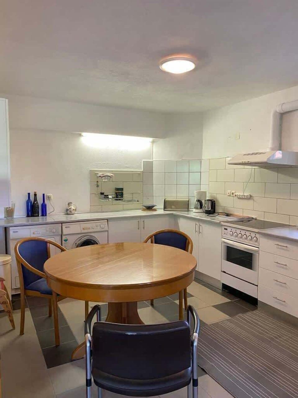 Modern open-plan kitchen fully equipped for self-catering, with cozy dining area and natural light.