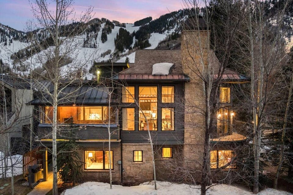 Outside of the Townhome Lit Up at Night with Aspen Mountain in the Background