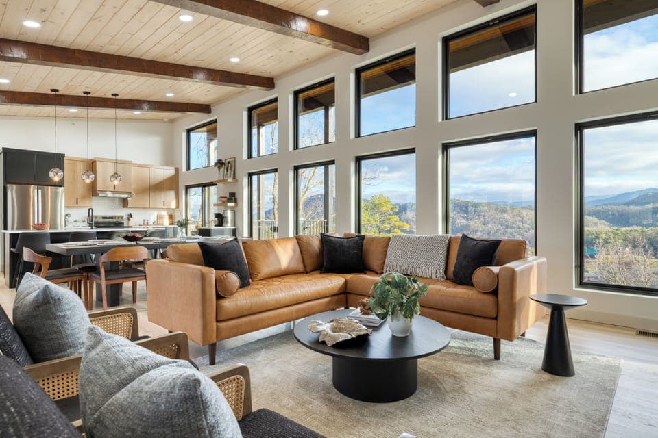 Bright open-concept living area with floor-to-ceiling windows framing panoramic Smoky Mountain views.