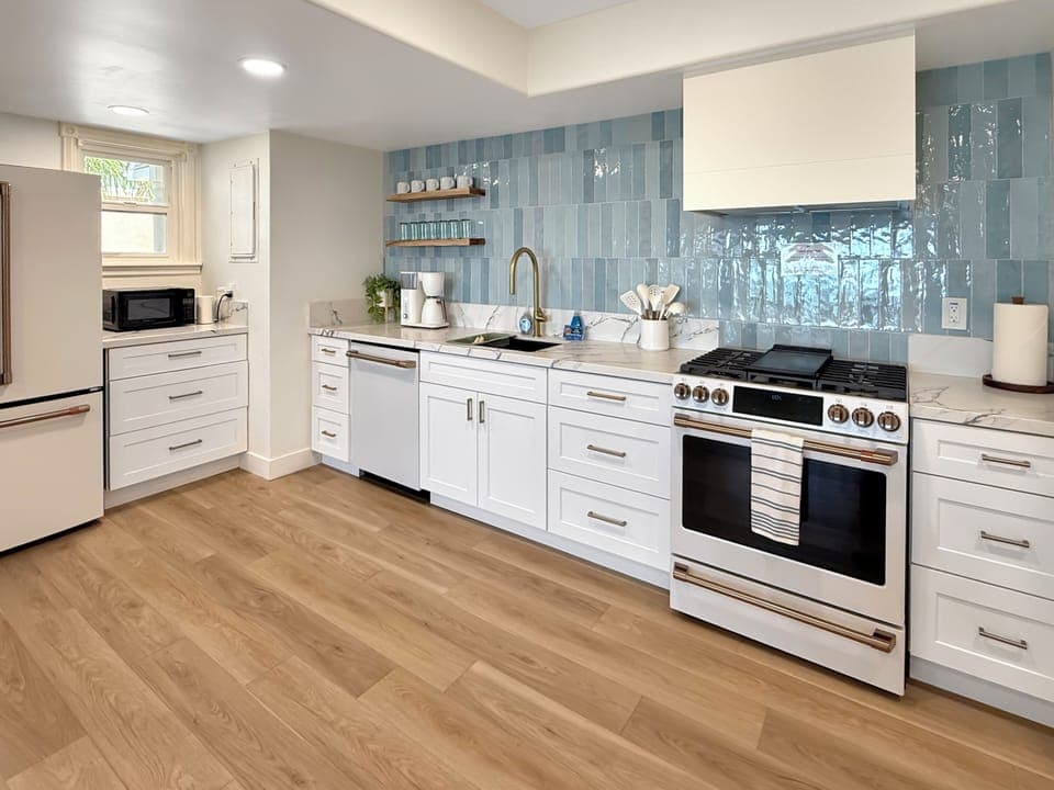 Cook memorable meals in your gourmet kitchen featuring gleaming appliances, gorgeous blue tiles, and everything you need for culinary adventures.