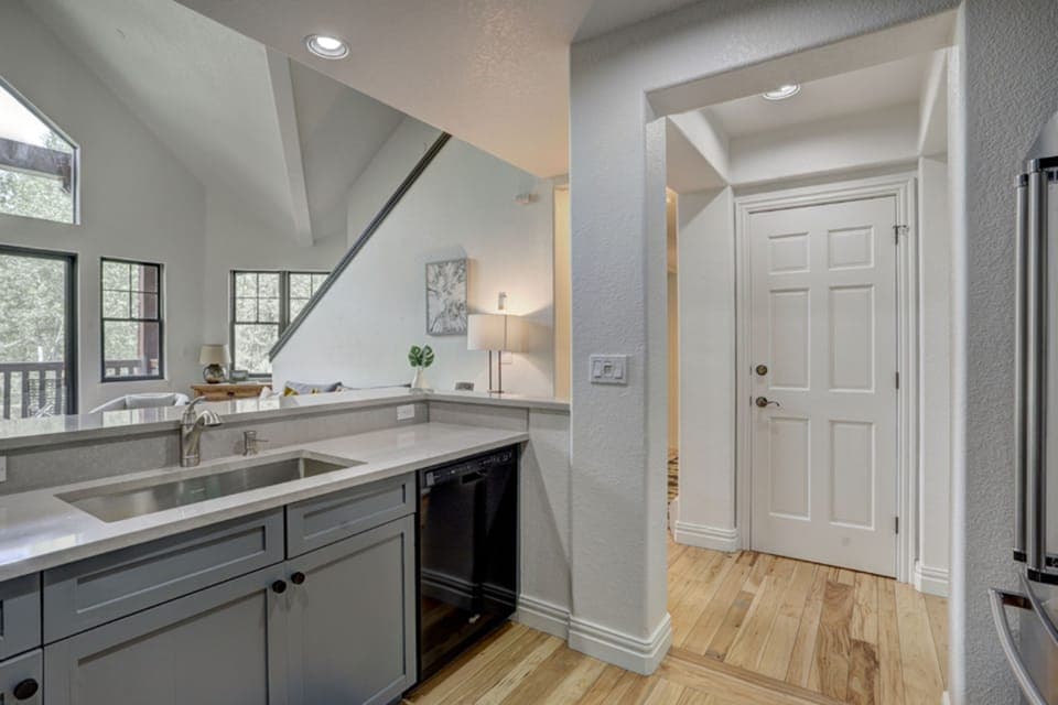 Bright natural light pours through the vaulted windows, illuminating an airy galley kitchen that blends beauty with function.