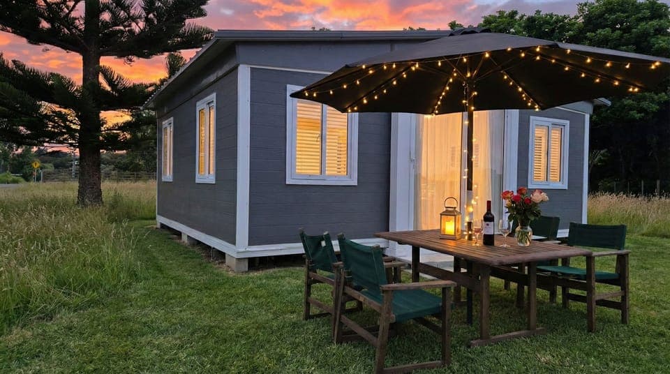 Front of cabin with dining table and umbrella