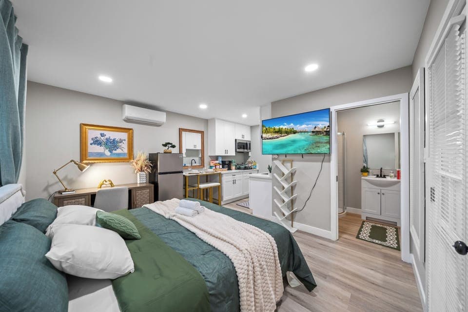 Relax in a cozy bed with a TV for comfort and entertainment.