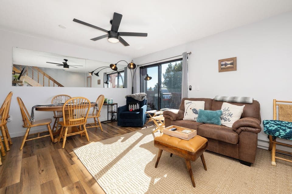 Relax in your bright, open living space at Soda Springs Ranch condo 3C with cozy seating, warm wood accents, and natural light streaming through large windows.