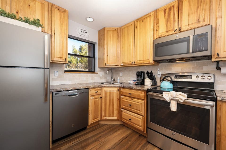 Cook with ease in your fully equipped kitchen at Soda Springs Ranch condo 3C , featuring warm wood cabinets, granite counters, and stainless steel appliances including dishwasher and microwave.