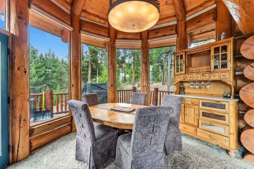 Gather around this rustic dining table surrounded by panoramic forest views—your perfect spot for memorable meals and warm conversations.