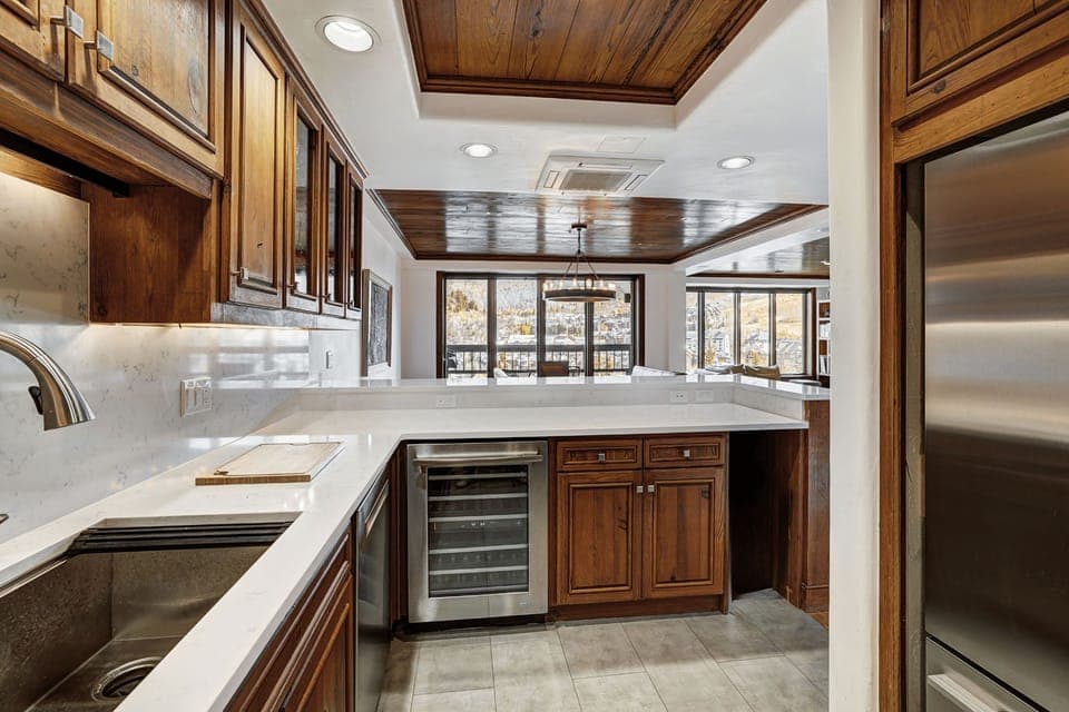 Bright and spacious kitchen featuring stainless-steel appliances, bar seating, and a touch of alpine sophistication.