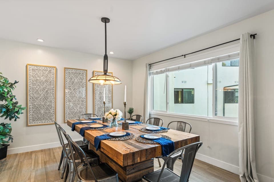 Dining area with large windows and a wooden table.