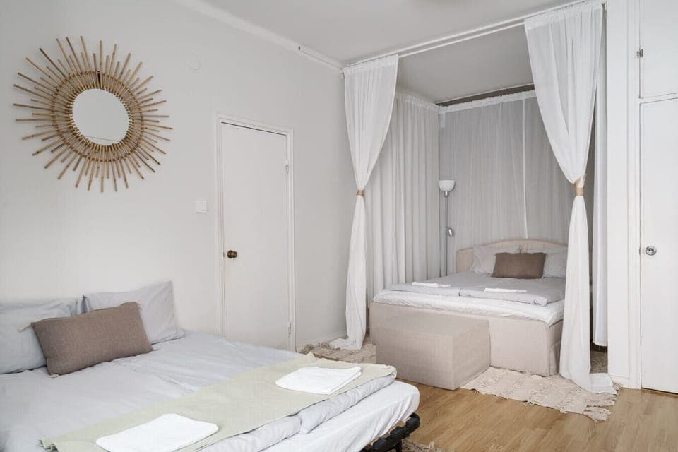 The room is filled with light, enhanced by the predominantly white and neutral color palette and light wood flooring, creating a feeling of spaciousness and serenity.