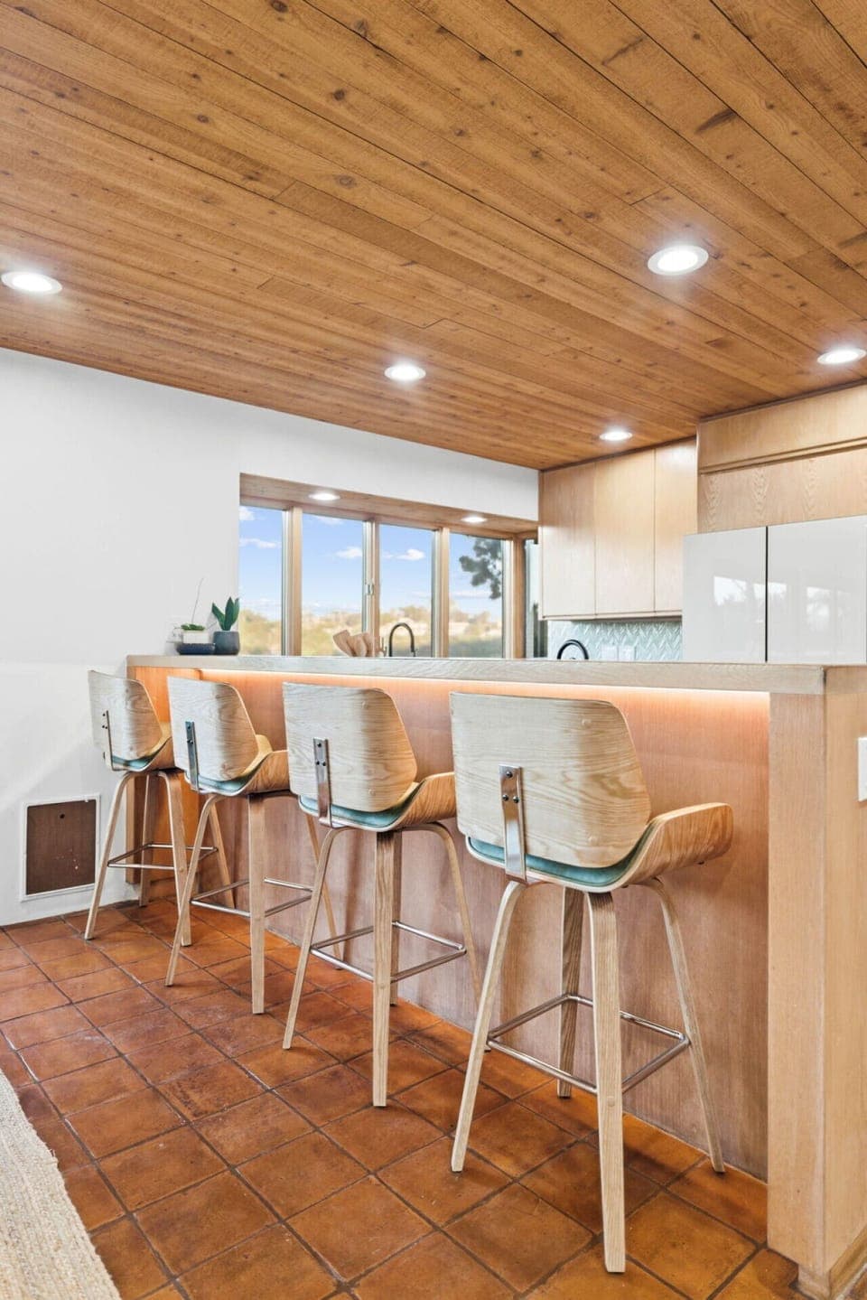 A warm, inviting breakfast bar pairs natural wood tones with scenic views for a relaxed, stylish kitchen setting.
