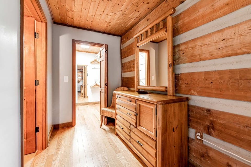 Natural wood accents and a welcoming mirror create a charming entryway experience!
