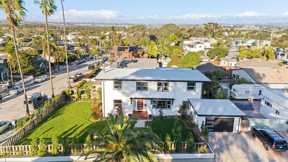 Aerial view of the home with a large yard and bright two-story exterior.