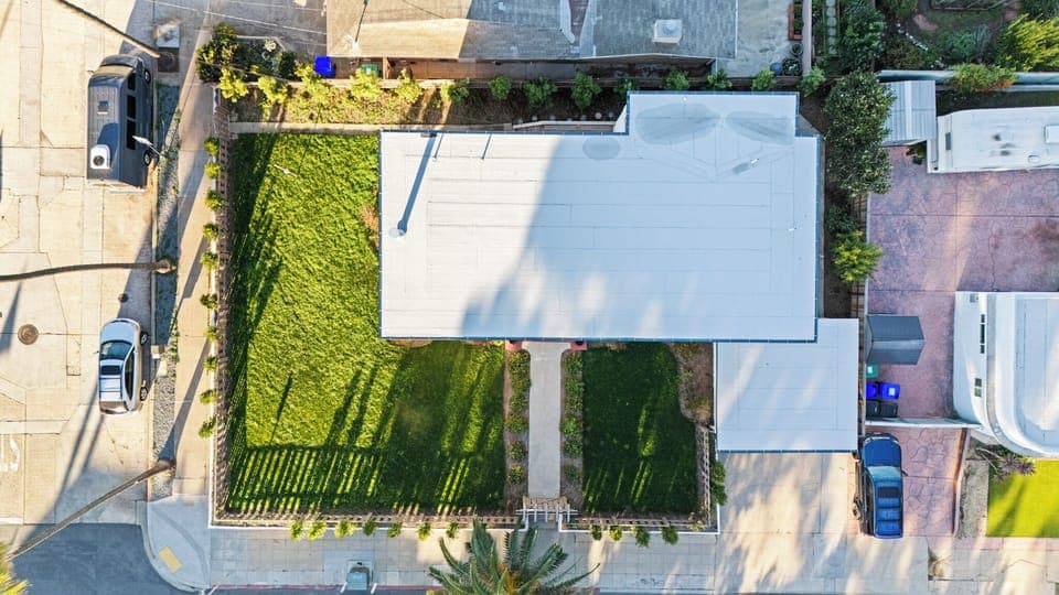 Overhead view of the home’s roof and green backyard.