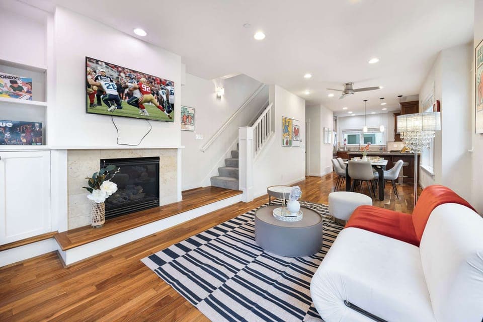 Open-concept living and dining area filled with natural light and vibrant art.