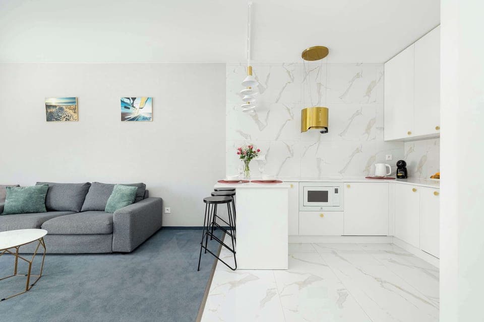 A similar living room angle focusing on the seating area. Soft carpeting and stylish furniture create a pleasant atmosphere. The space looks comfortable and organized.