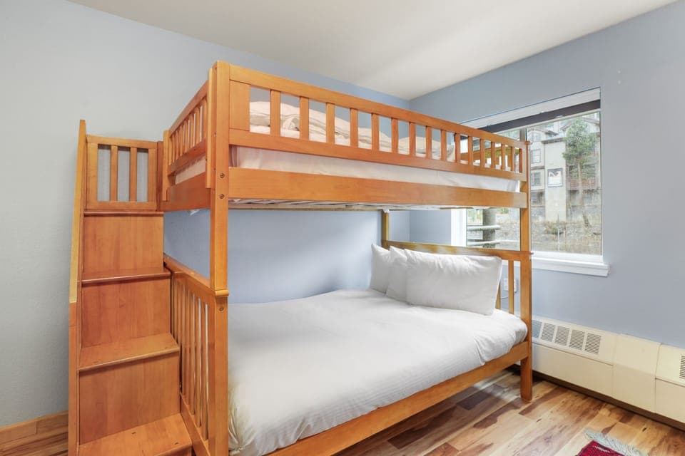 Discover the perfect family hideaway! This playful bunk room features plenty of space and natural light, setting the stage for adventure and comfort after a day on the slopes.