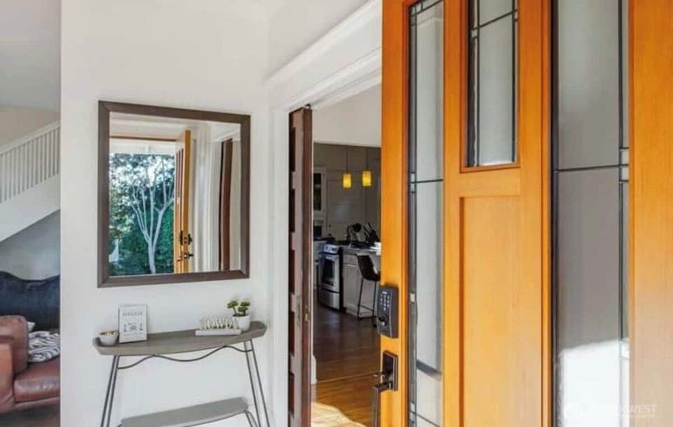 客厅 Living Room
Natural light pours in through large windows, enhancing the neutral color palette and polished hardwood floors. A well-placed console table and mirror add a touch of style and functionality to the entryway, making it easy to grab essen