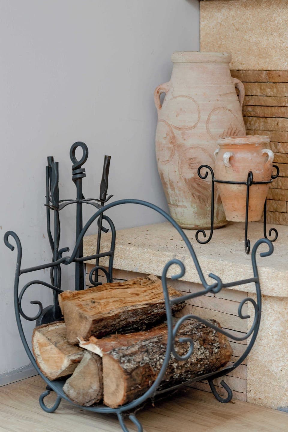 The metal log holder by the fireplace adds a rustic touch and enhances the cozy feel of evenings spent indoors.