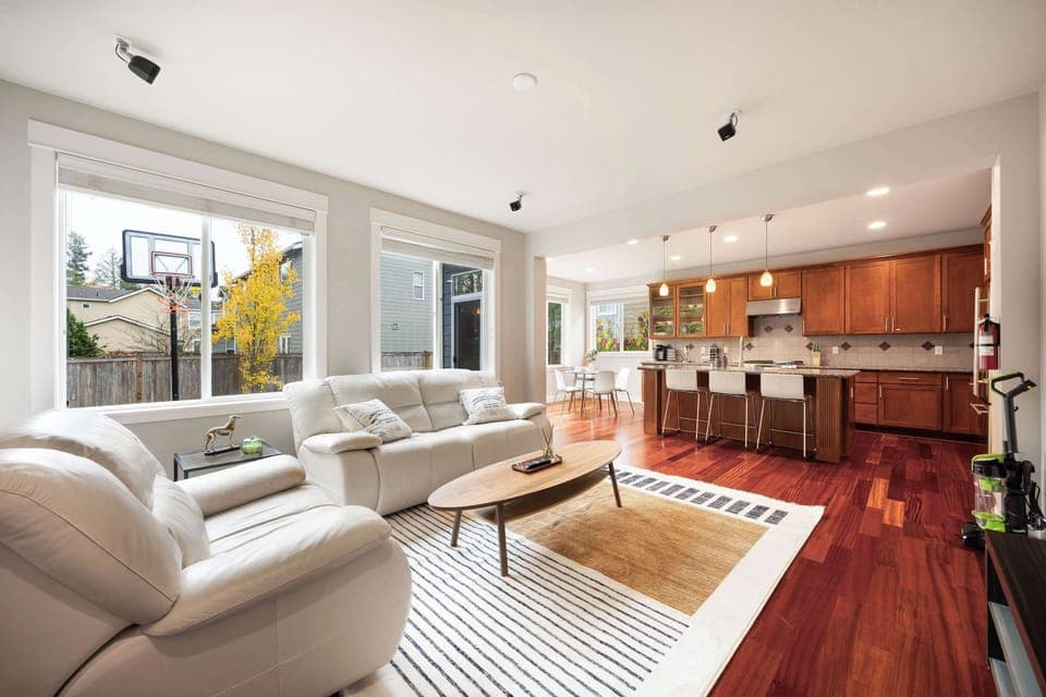 Sun-filled living area with cozy seating and views of the backyard.