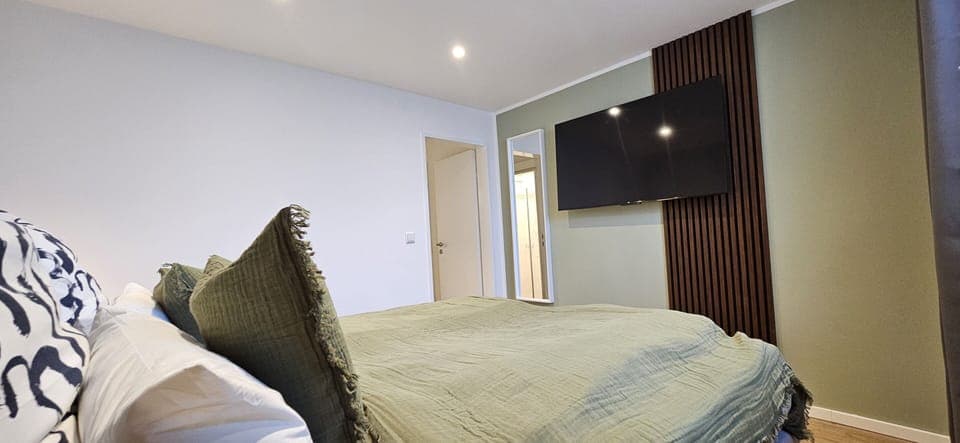 Bedroom with TV and box spring bed