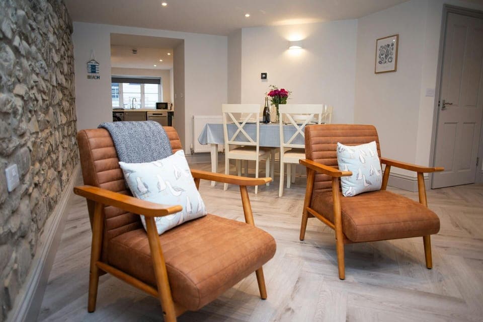 Living and dining area, two armchairs, view of dining area with table and chairs