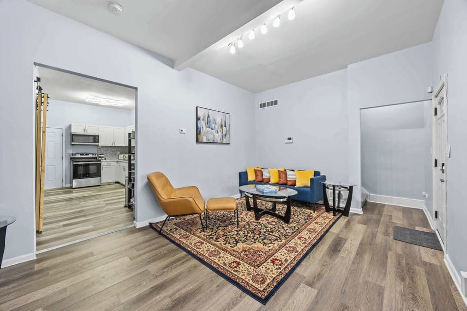 Living Area: This living room features sturdy, practical furniture built for extended use, ensuring longevity and comfort for families or traveling colleagues. Our home's clean, open layout offers maximum functional flexibility.