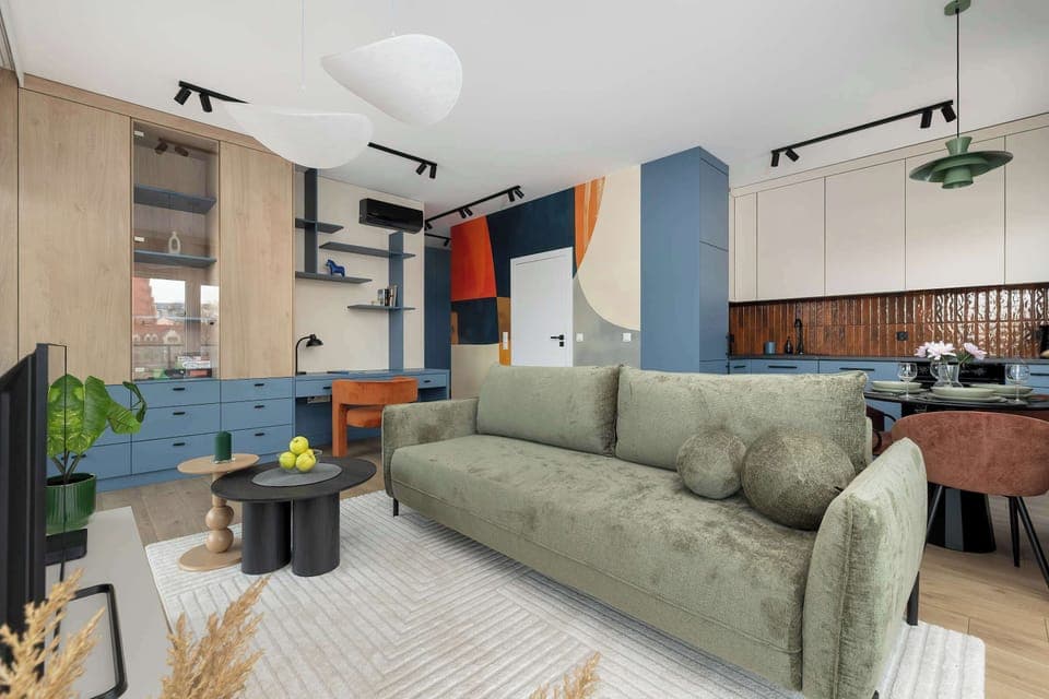 The soft green sofa combined with warm natural light creates a space where you can instantly unwind after a full day of exploring.