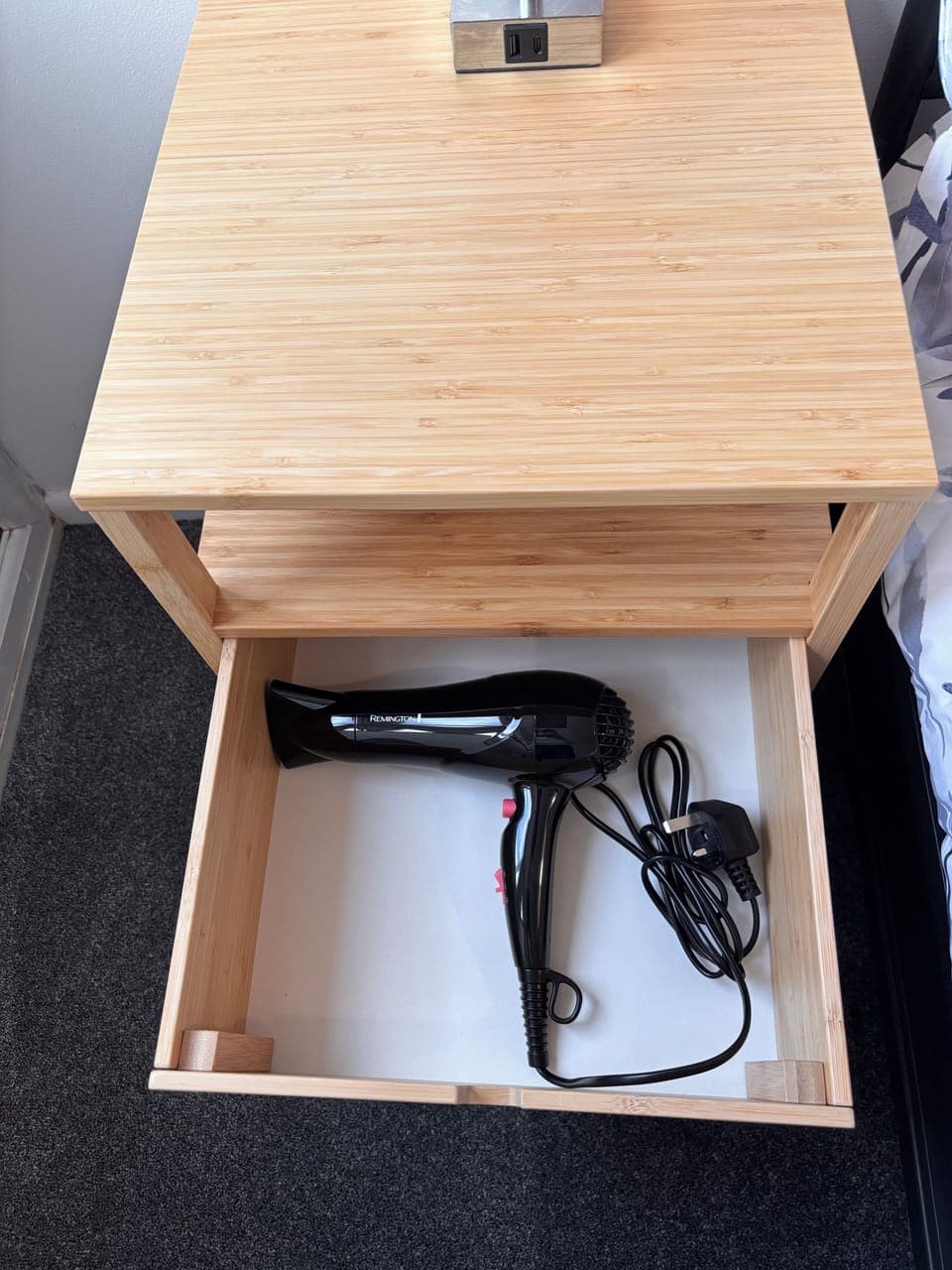 There is a hair dryer in the bedside table