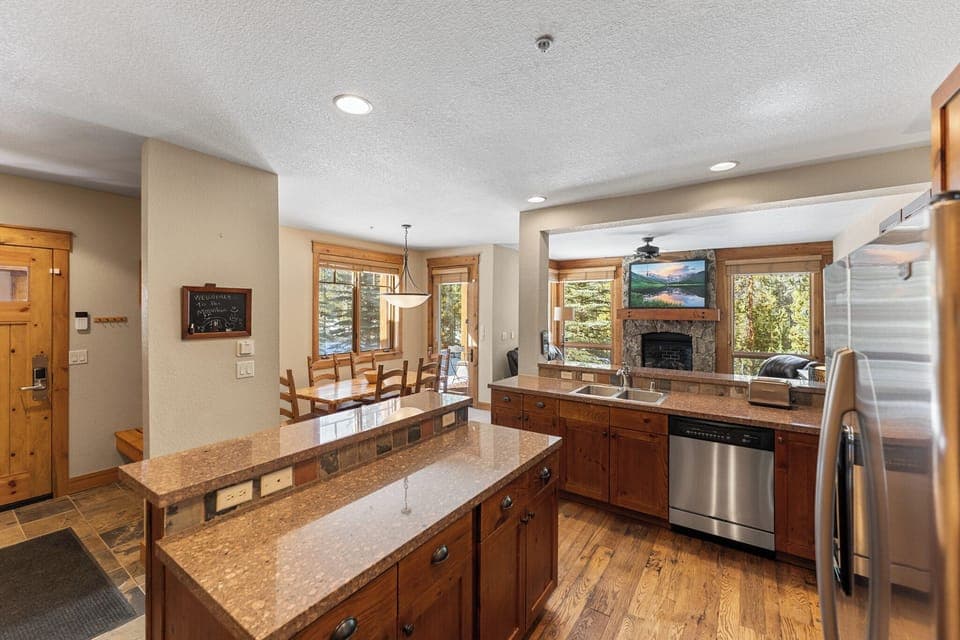 Full kitchen with stainless steel appliances and breakfast bar.