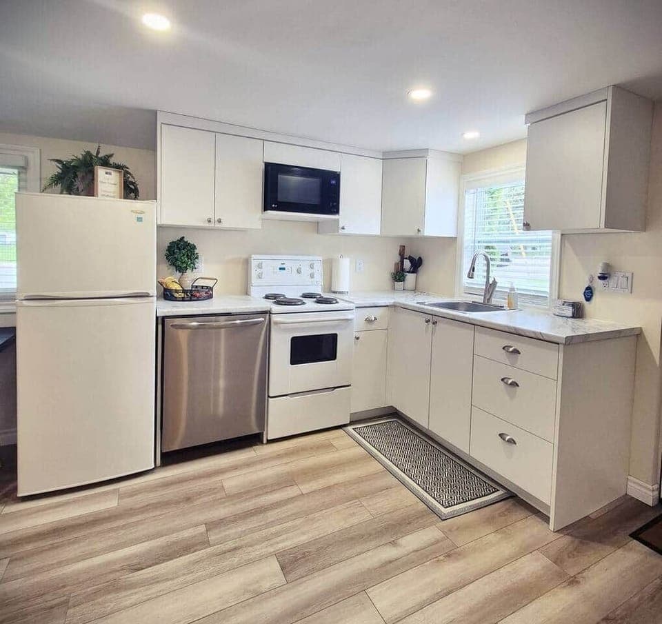 Full kitchen, featuring an oven/stove, microwave, fridge/freezer and dishwasher.
