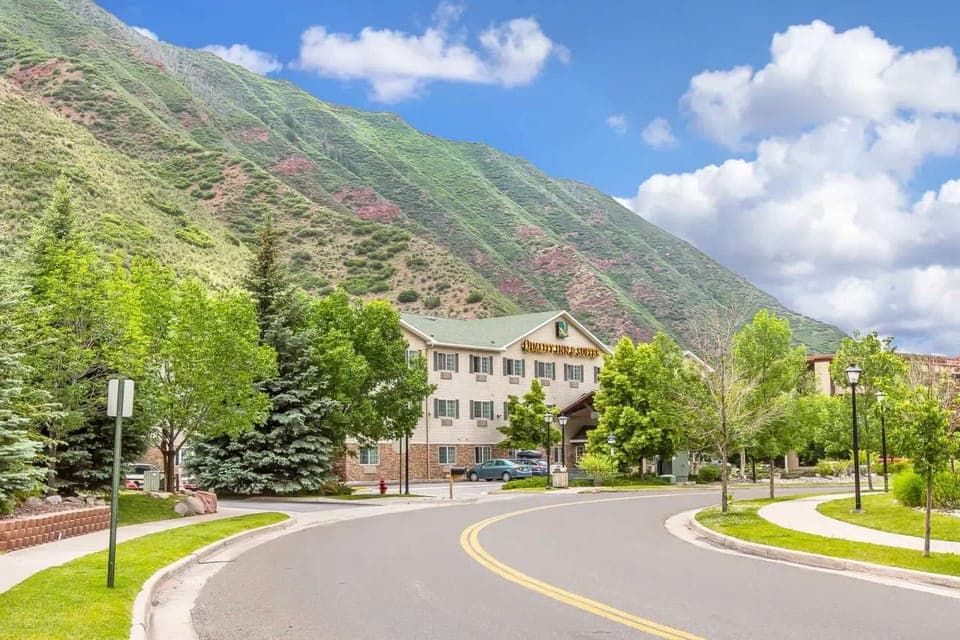 Roadside view of inn surrounded by trees and scenic green hills
