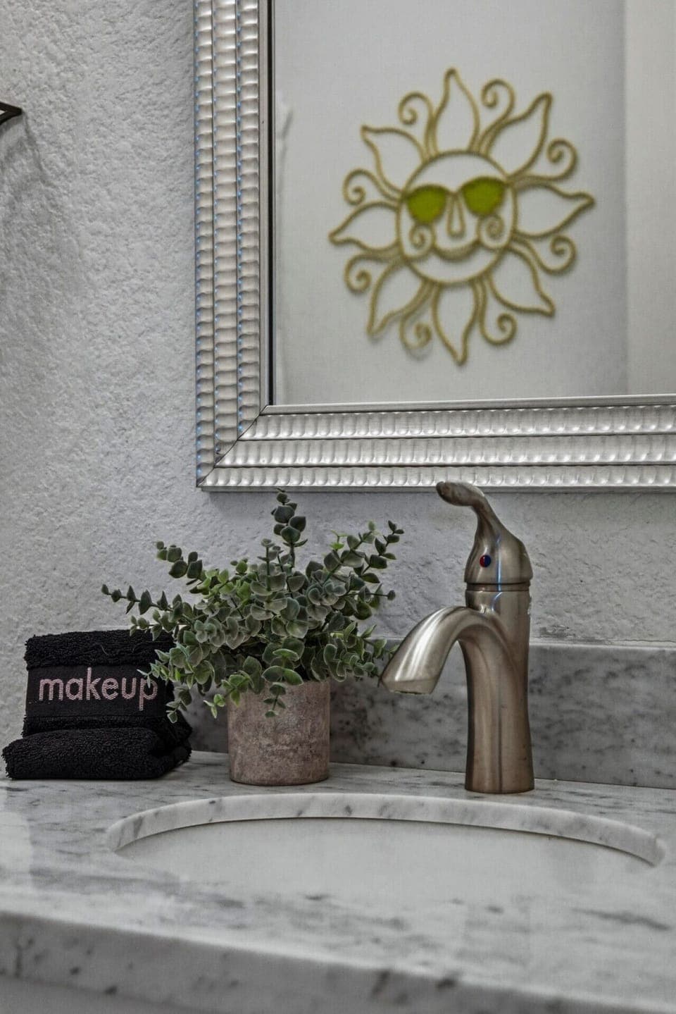 Start your day with a smile—marble vanity, cheerful sun mirror, and plush towels bring a little extra joy to your morning routine.