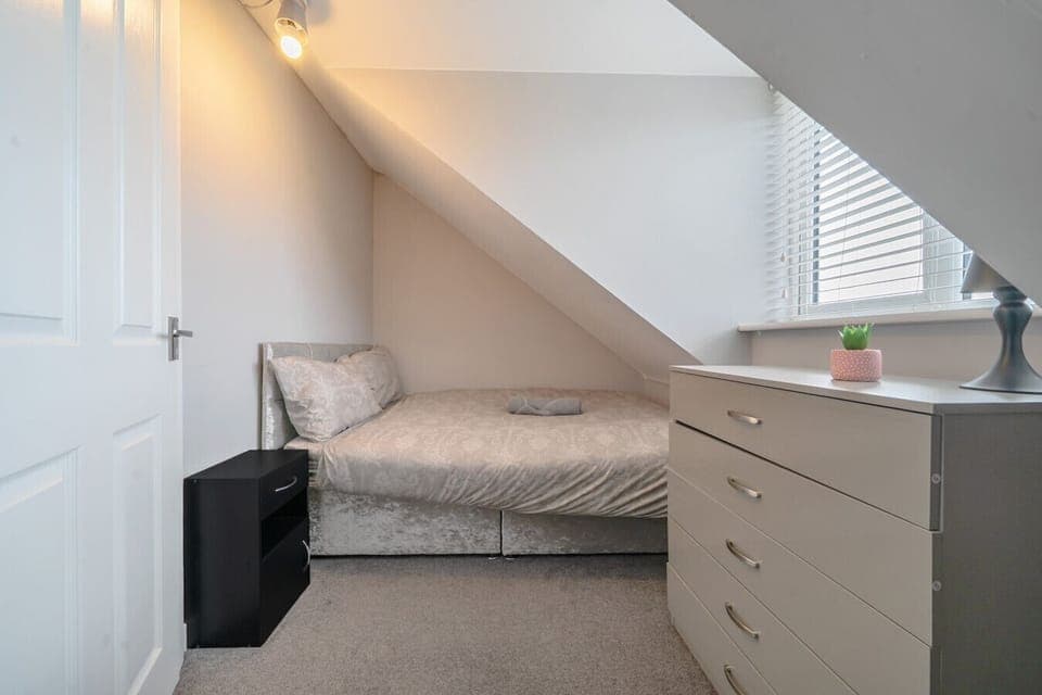 Compact bedroom with a double bed, chest of drawers and a skylight.