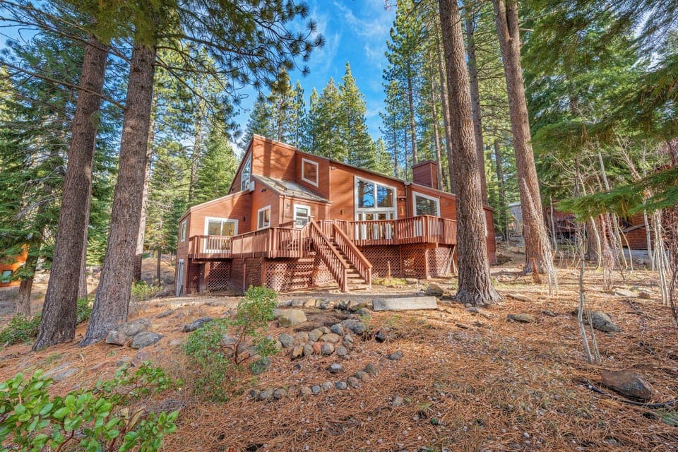 This spacious cabin sits on a forested lot with expansive decks and sun-filled windows overlooking the trees.